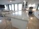 Kitchen featuring white cabinets, travertine floors, granite countertops, stainless steel appliances and a wine fridge at 6415 Midnight Pass Rd # 904, Sarasota, FL 34242