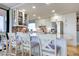 Modern white kitchen with stainless steel appliances, herringbone backsplash, and seating at the large island at 6415 Midnight Pass Rd # 904, Sarasota, FL 34242