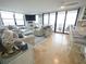 Open-concept living area with plenty of seating, travertine floors, and sliding glass doors to the balcony at 6415 Midnight Pass Rd # 904, Sarasota, FL 34242