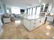 The living room flows into the kitchen, featuring a large island and travertine floors throughout at 6415 Midnight Pass Rd # 904, Sarasota, FL 34242