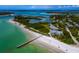 Breathtaking aerial view of a pristine beach with crystal-clear water and beachfront estates, showcasing coastal living at its finest at 660 Fox St, Longboat Key, FL 34228