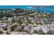 Aerial view of a blue single-Gathering home surrounded by lush greenery in a coastal neighborhood near a bridge at 660 Fox St, Longboat Key, FL 34228