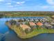 Aerial view of home showcasing waterfront property on a peninsula with lush landscaping at 7108 Callander Cv, Lakewood Ranch, FL 34202