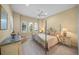 Relaxing primary bedroom featuring a four poster bed, sitting area, and elegant decor at 7108 Callander Cv, Lakewood Ranch, FL 34202