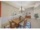 An elegant dining room with a chandelier, wainscoting, and stylish furnishings, creating an ideal space for formal dining at 7108 Callander Cv, Lakewood Ranch, FL 34202