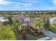 An impressive single-story home with a tile roof, lush landscaping, and picturesque lake views from an elevated perspective at 7108 Callander Cv, Lakewood Ranch, FL 34202