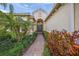 A welcoming front entrance featuring a beautifully landscaped walkway leading to the elegant front door and well-maintained property at 7108 Callander Cv, Lakewood Ranch, FL 34202