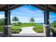 Picturesque view of the golf course, framed by stone columns and palm trees at 7108 Callander Cv, Lakewood Ranch, FL 34202