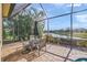 Screened lanai features brick flooring, dining set, and a lovely view of the community's serene lake at 7108 Callander Cv, Lakewood Ranch, FL 34202