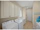 Functional laundry room with washer, dryer, utility sink, and ample cabinet space at 7108 Callander Cv, Lakewood Ranch, FL 34202