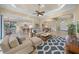 Open-concept living room featuring modern furniture, ceiling fan, and seamlessly connecting to the kitchen and dining area at 7108 Callander Cv, Lakewood Ranch, FL 34202