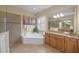 Bathroom featuring a soaking tub, shower, and granite counters at 7108 Callander Cv, Lakewood Ranch, FL 34202
