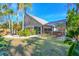 Exterior of house and tropical backyard showcases a screened-in porch and lush landscaping at 7821 Geneva Ln # 11, Sarasota, FL 34243