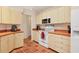 Well-lit kitchen features tile flooring, white appliances, and ample cabinet space at 7821 Geneva Ln # 11, Sarasota, FL 34243