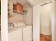 Functional laundry room features washer, dryer, and wire shelving for storage, next to an open doorway at 7821 Geneva Ln # 11, Sarasota, FL 34243