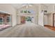 Bright, carpeted living room features high ceilings and access to both an enclosed and outdoor patio at 7821 Geneva Ln # 11, Sarasota, FL 34243