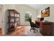 Home office featuring tile floors, arched window, desk and bookshelf at 7821 Geneva Ln # 11, Sarasota, FL 34243