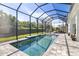 Inviting screened-in pool area with a covered lanai, lush landscaping, and relaxing lounge furniture at 8014 Planters Knoll Ter, Bradenton, FL 34201