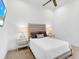 Simple bedroom featuring carpeted floors and a bed with striped headboard flanked by matching bedside tables at 8016 Bowspirit Way, Lakewood Ranch, FL 34202