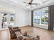 Living room with hardwood floors, decorative trim, and pool views from the expansive glass windows at 8016 Bowspirit Way, Lakewood Ranch, FL 34202