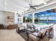 Beautiful outdoor living area with a fireplace, comfortable seating, and a view of the pool and lake at 8016 Bowspirit Way, Lakewood Ranch, FL 34202