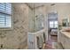 Luxurious bathroom with a glass-enclosed shower, marble walls, double vanity and modern fixtures at 8192 Sternway Rd, Sarasota, FL 34240