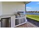 Outdoor kitchen with stainless steel grill and scenic views adds a touch of luxury to the property at 8192 Sternway Rd, Sarasota, FL 34240