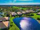 Aerial view showcases homes with beautiful landscaping next to a lake at 8310 Tartan Fields Cir, Lakewood Ranch, FL 34202