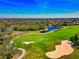 Aerial view of a golf course with a sand trap and a blue pond at 8310 Tartan Fields Cir, Lakewood Ranch, FL 34202