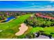 Scenic aerial view showcases a lush golf course with a serene pond and beautifully landscaped homes at 8310 Tartan Fields Cir, Lakewood Ranch, FL 34202