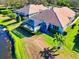 Home with a screened-in pool area, lush landscaping, and serene pond view at 8310 Tartan Fields Cir, Lakewood Ranch, FL 34202