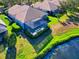 Home showcasing its screened-in pool area, lush landscaping, and serene pond view at 8310 Tartan Fields Cir, Lakewood Ranch, FL 34202