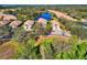 Beautifully landscaped homes beside a pond, captured in an aerial view that showcases neighborhood charm and lush surroundings at 8310 Tartan Fields Cir, Lakewood Ranch, FL 34202