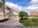 Charming beige home with a neatly manicured lawn, mature tree and spacious two car garage at 8310 Tartan Fields Cir, Lakewood Ranch, FL 34202