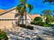 Inviting beige home with a well-manicured lawn, lush landscaping, and a convenient three-car garage at 8310 Tartan Fields Cir, Lakewood Ranch, FL 34202