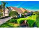 Attractive single-story home featuring lush landscaping, a well-maintained lawn, and a serene lakeside view at 8310 Tartan Fields Cir, Lakewood Ranch, FL 34202