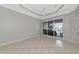 Neutral living room featuring sliding glass doors to screened patio at 8310 Tartan Fields Cir, Lakewood Ranch, FL 34202
