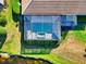 Aerial view of a screened in pool and well-maintained backyard with adjacent pond at 8310 Tartan Fields Cir, Lakewood Ranch, FL 34202