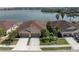 Beautiful waterfront home featuring a two-car garage, mature landscaping, and stunning lake views at 8947 Tuscany Isles Dr, Punta Gorda, FL 33950