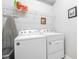 Bright laundry room equipped with a Whirlpool washer and dryer, along with overhead storage shelves at 8947 Tuscany Isles Dr, Punta Gorda, FL 33950