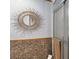 Bathroom with a shower and a unique sunburst mirror above earth-tone stone tile at 970 Jolanda Cir, Venice, FL 34285