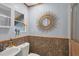 Charming bathroom showcasing a sink, toilet, and window with wood-look tile wall accents at 970 Jolanda Cir, Venice, FL 34285