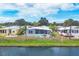 An eye-level aerial shot shows pastel homes with patios overlooking a canal in a quiet 55+ community at 970 Jolanda Cir, Venice, FL 34285