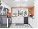 Bright kitchen with stainless steel appliances, white cabinetry, and a charming bay window at 970 Jolanda Cir, Venice, FL 34285