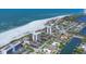 Stunning aerial view of beachfront condos, lush neighborhood, and the ocean along a pristine white sandy beach at 101 Benjamin Franklin Dr # 71, Sarasota, FL 34236