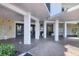 Under building entrance featuring stone columns, a paved driveway and tropical landscaping at 101 Benjamin Franklin Dr # 71, Sarasota, FL 34236