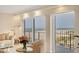 Bright living room showcasing balcony access with beautiful beach views and comfortable, neutral decor at 101 Benjamin Franklin Dr # 71, Sarasota, FL 34236