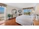 Bright main bedroom featuring hardwood floors, dresser with mirror, television, and large windows with a view of the beach at 101 Benjamin Franklin Dr # 71, Sarasota, FL 34236