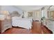 Bright main bedroom featuring hardwood floors, dressers, an ensuite bath, and tasteful decor at 101 Benjamin Franklin Dr # 71, Sarasota, FL 34236