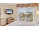 Bright main bedroom featuring hardwood floors, a cozy chair, and large windows with a view of the beach at 101 Benjamin Franklin Dr # 71, Sarasota, FL 34236